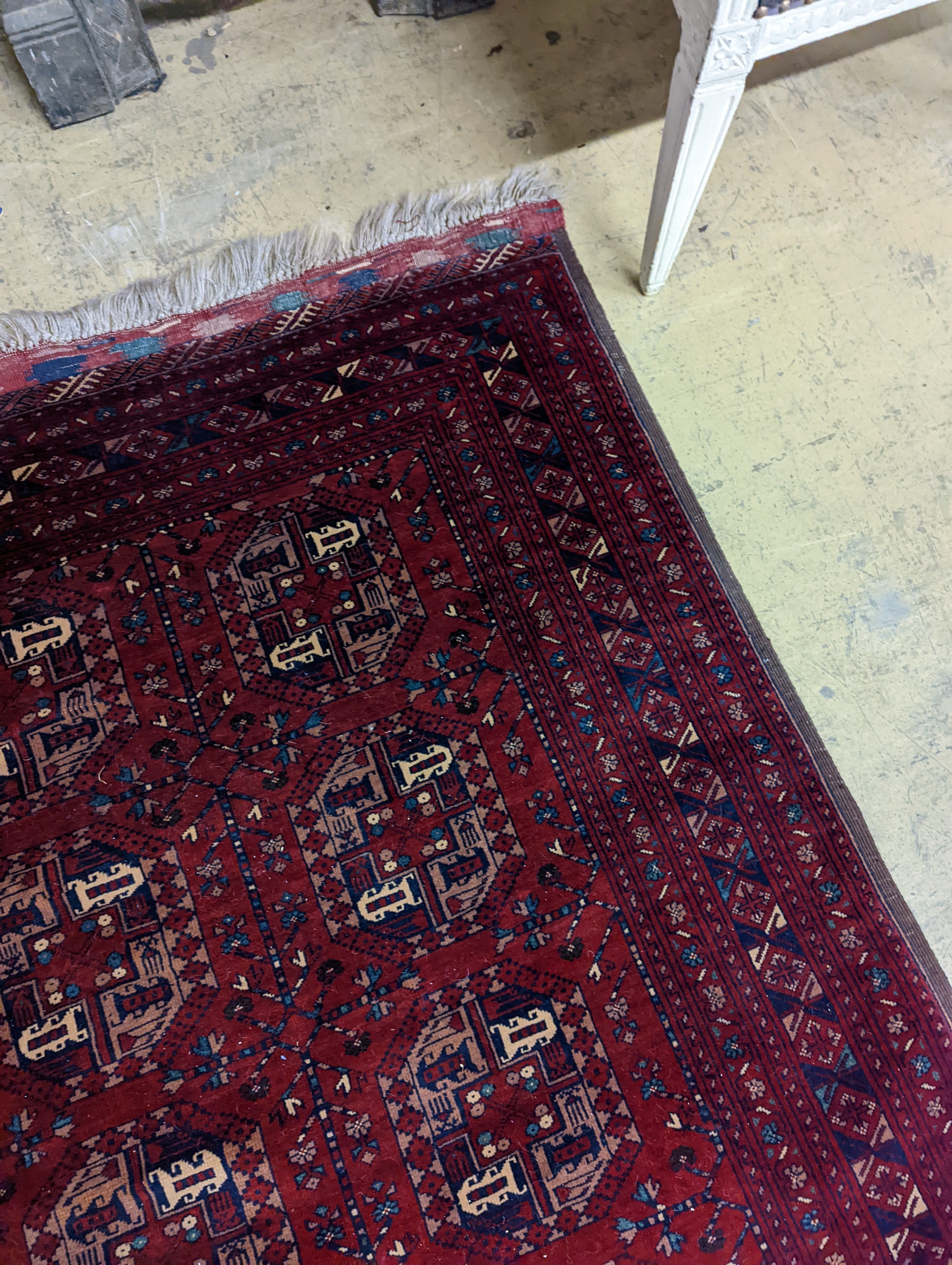 A Belouch red ground rug woven with octagonal motifs, 190 x 124 cms.
